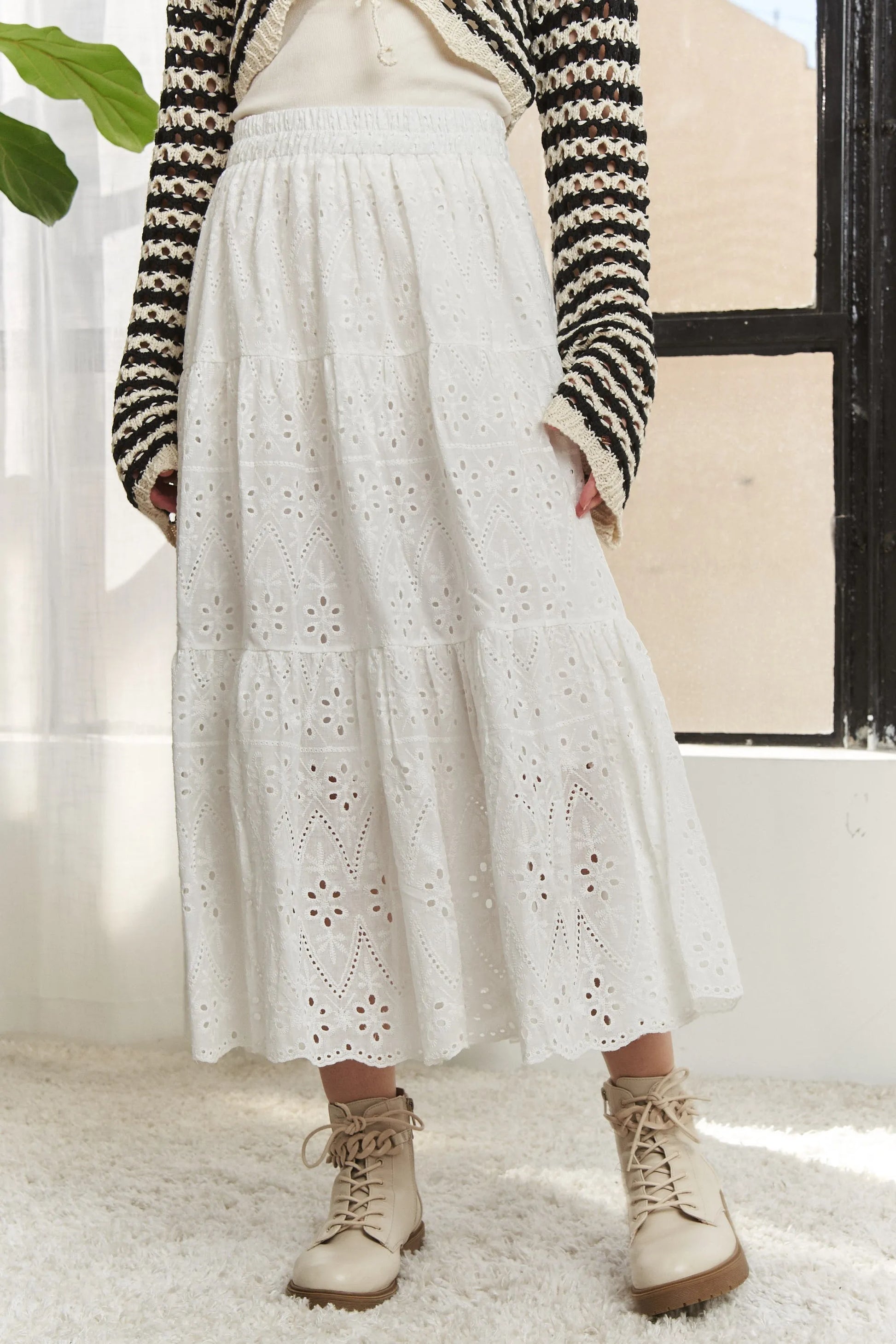 White ADORA elastic waistband tiered midi skirt by Trendsi, featuring flowing fabric and layered design.