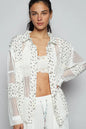 White floral crochet patchwork long sleeve shirt by Trendsi featuring intricate embroidery and lightweight fabric.