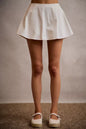 White SO ME denim bubble skort with smocked back, featuring a casual, stylish design and comfortable fit.
