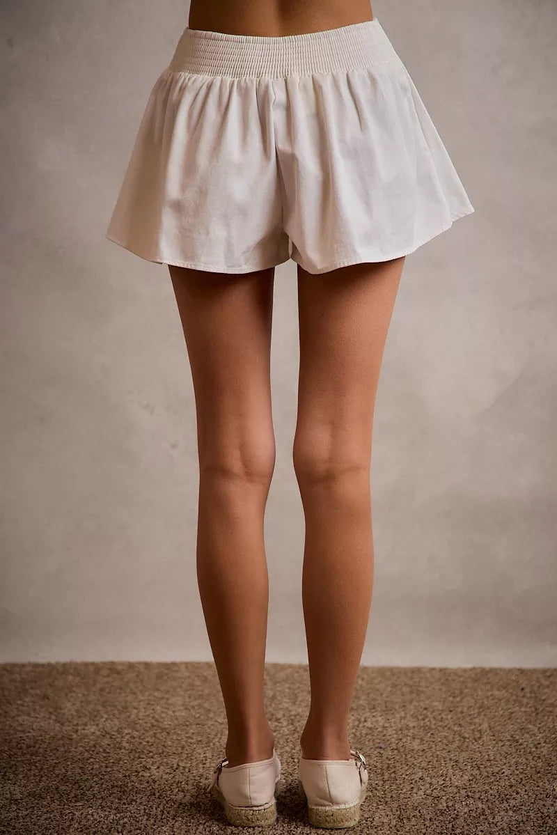 White denim bubble skort from Trendsi with smocked back, casual style, and relaxed fit, shown on a model.
