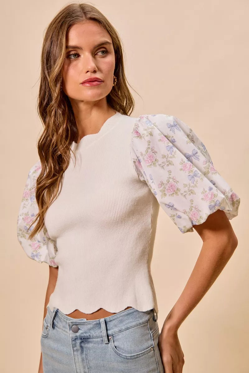 White floral cotton sweater top with contrast sleeves and scalloped hem by Trendsi, featuring a stylish and feminine design.