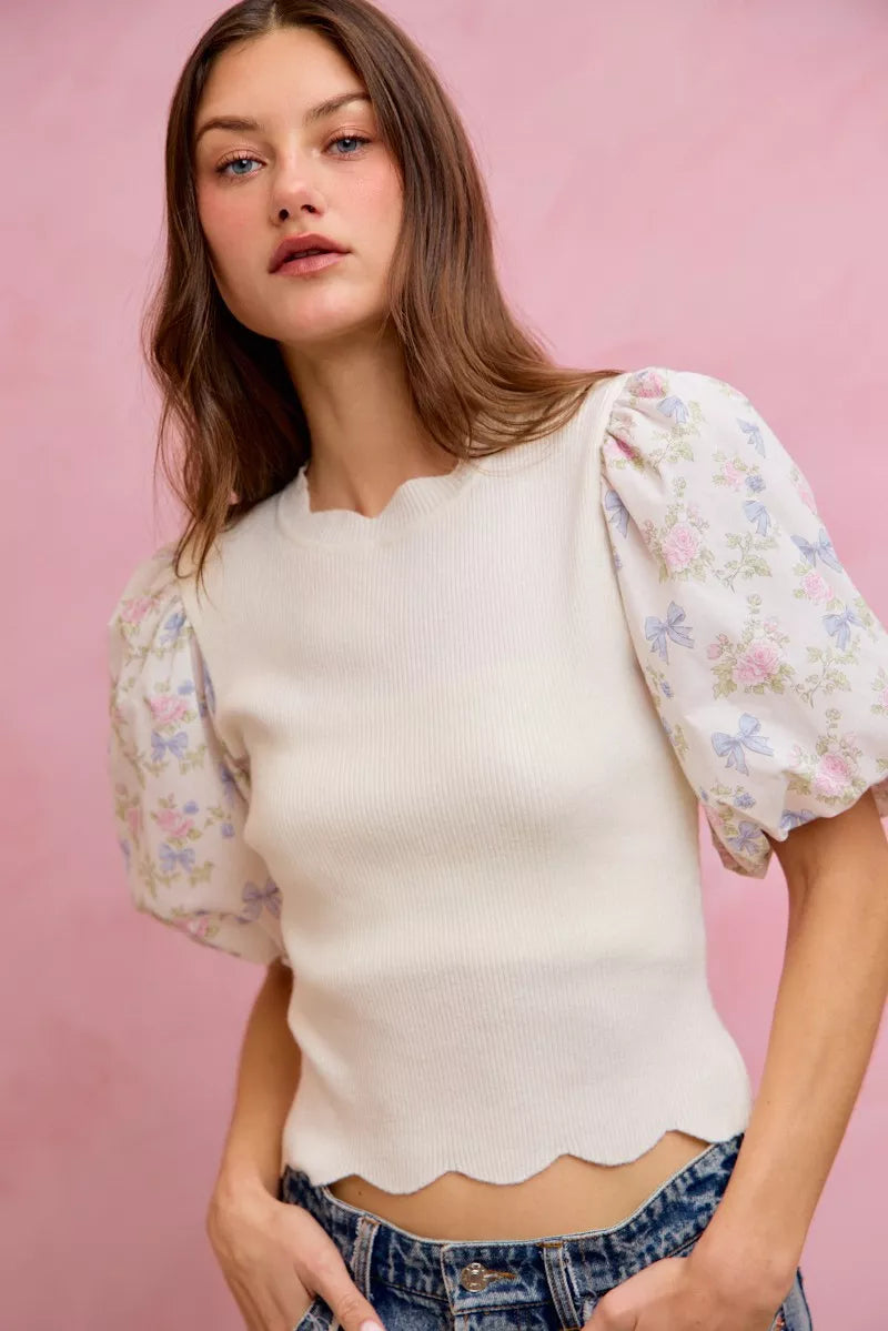 White floral cotton sweater top with contrast sleeves and scalloped hem from Trendsi, featuring a stylish and feminine design.