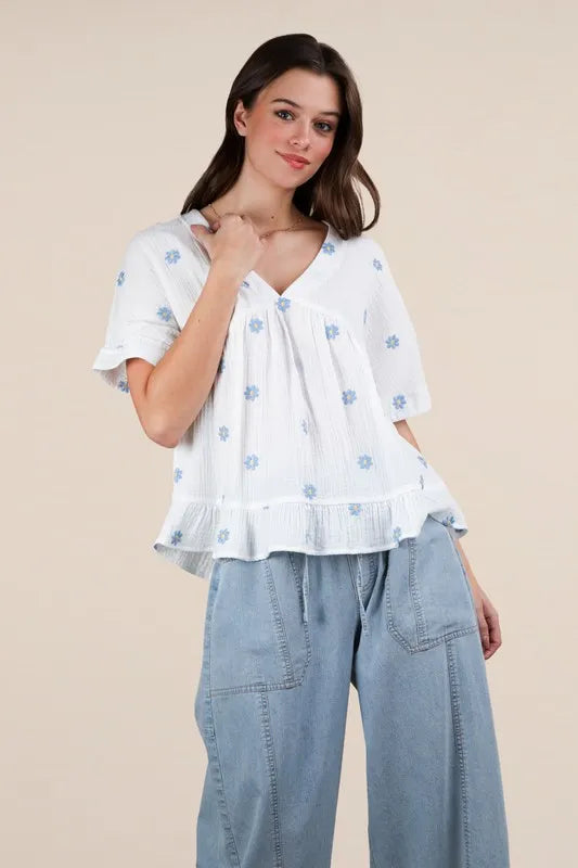 White woven blouse with embroidered floral design by VERY J Flower, styled for casual or dressy occasions.