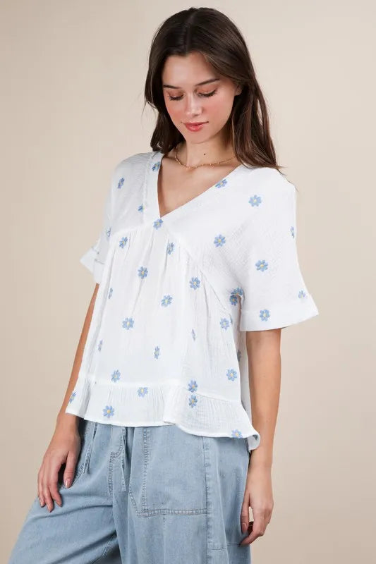 White woven blouse from Trendsi with intricate embroidered floral design, featuring a relaxed fit and lightweight fabric.