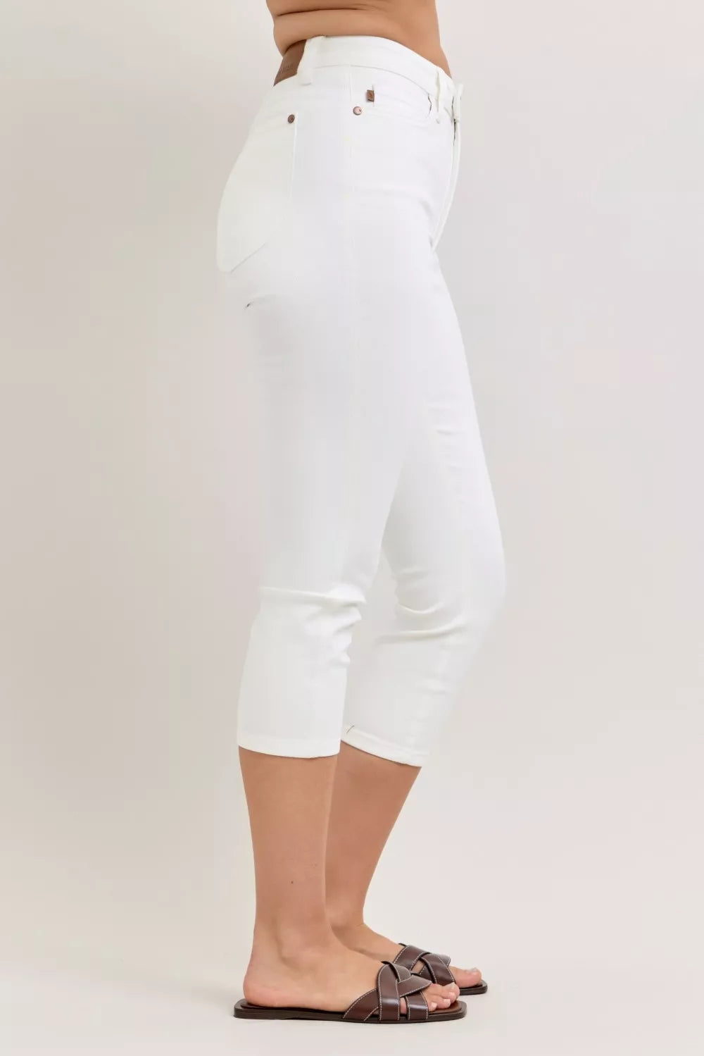 White Judy Blue high waist capri pants with extended waistband and spade pockets, displayed on a model.