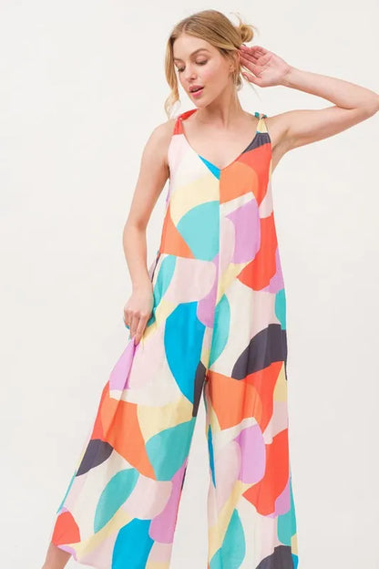 Yellow multi-colored geo print jumpsuit with tied shoulder straps and wide-leg design by Trendsi, perfect for casual wear.