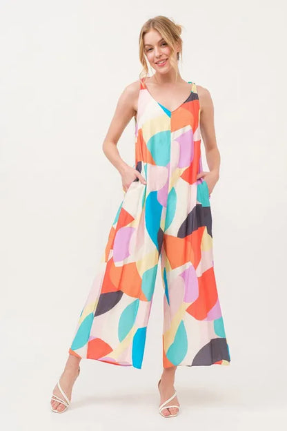 Yellow multi-colored geo print jumpsuit with tied shoulder straps and wide-leg pants by Trendsi.