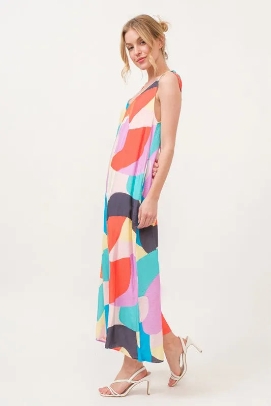 Yellow multi-color geo print jumpsuit with tied shoulder straps and wide-leg design by Trendsi.