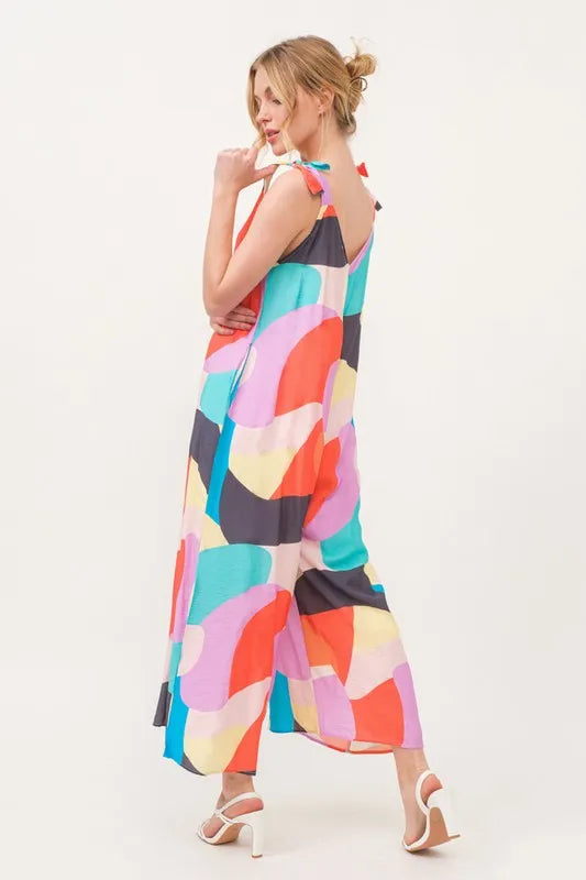 Yellow multi-color geo print jumpsuit with tied shoulder straps and wide-leg design from Trendsi, perfect for casual summer wear.