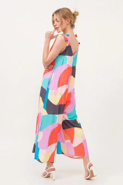 Yellow multi-color geo print jumpsuit with tied shoulder straps and wide-leg design from Trendsi, perfect for casual summer wear.