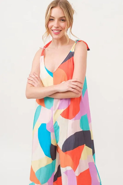 Yellow multi-color wide-leg geo print jumpsuit with tied shoulder straps from Trendsi, styled for a chic, casual look.