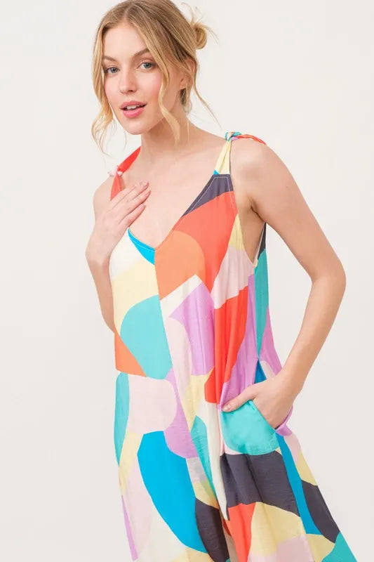 Yellow multi-color geo print jumpsuit with tied shoulder straps and wide-leg design by Trendsi, perfect for casual and stylish wear.