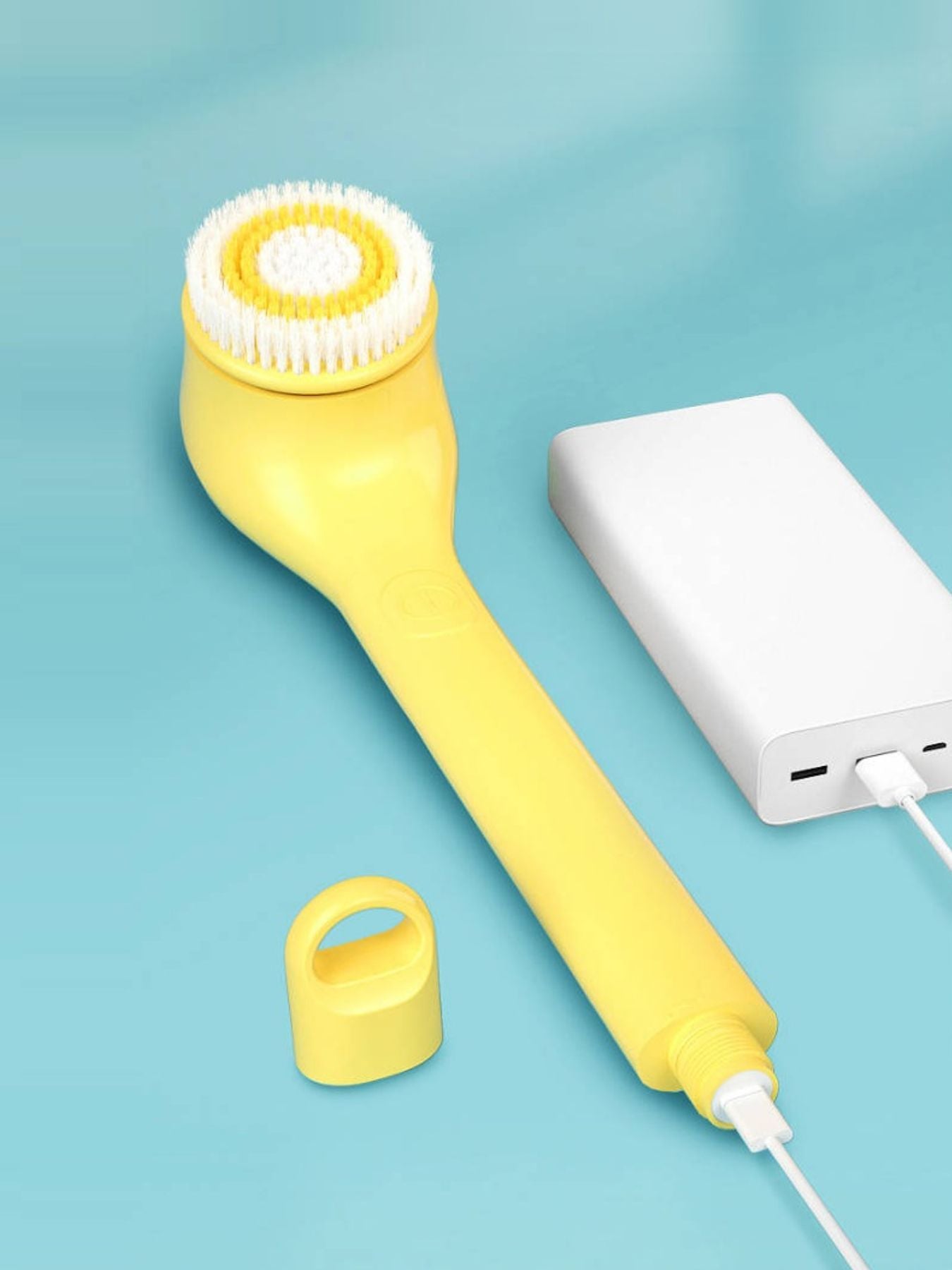 Yellow waterproof electric cleanser brush from Trendsi with a sleek design for facial skin cleansing.